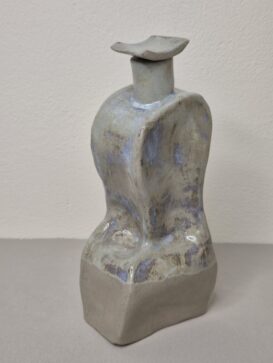 Karaffe ist in grauer Farbe, unten in grau matt und oben in glänzender grauer Farbe mit bläulichen Verläufen. Der Deckel ist leicht gebogen.